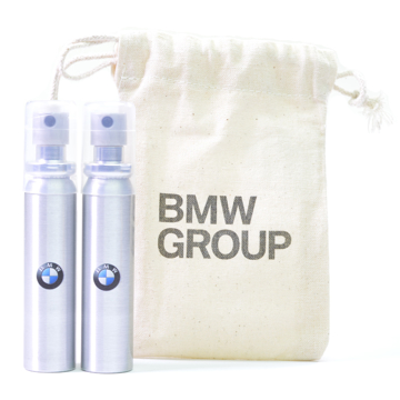 2 metal spray cans of sun screen with the BMW logo next to a cotton pouch also with BMW branding