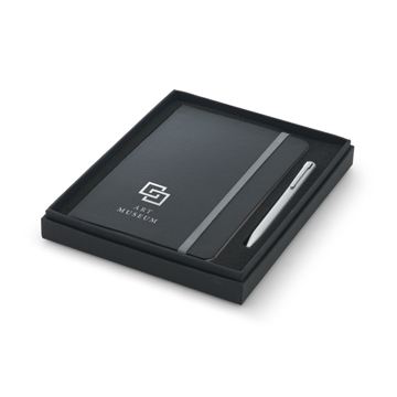 Notepad with hardcover in black with grey elastic closure strap and silver ball point pen in black box