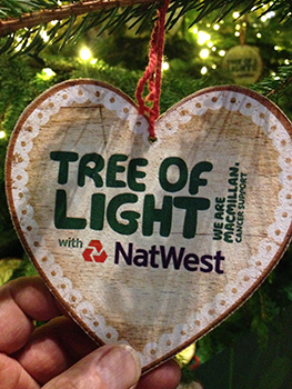A heart shaped bauble with the words the tree of light on it