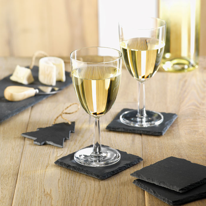 4 square dark grey slate coasters on display with wine glasses on them